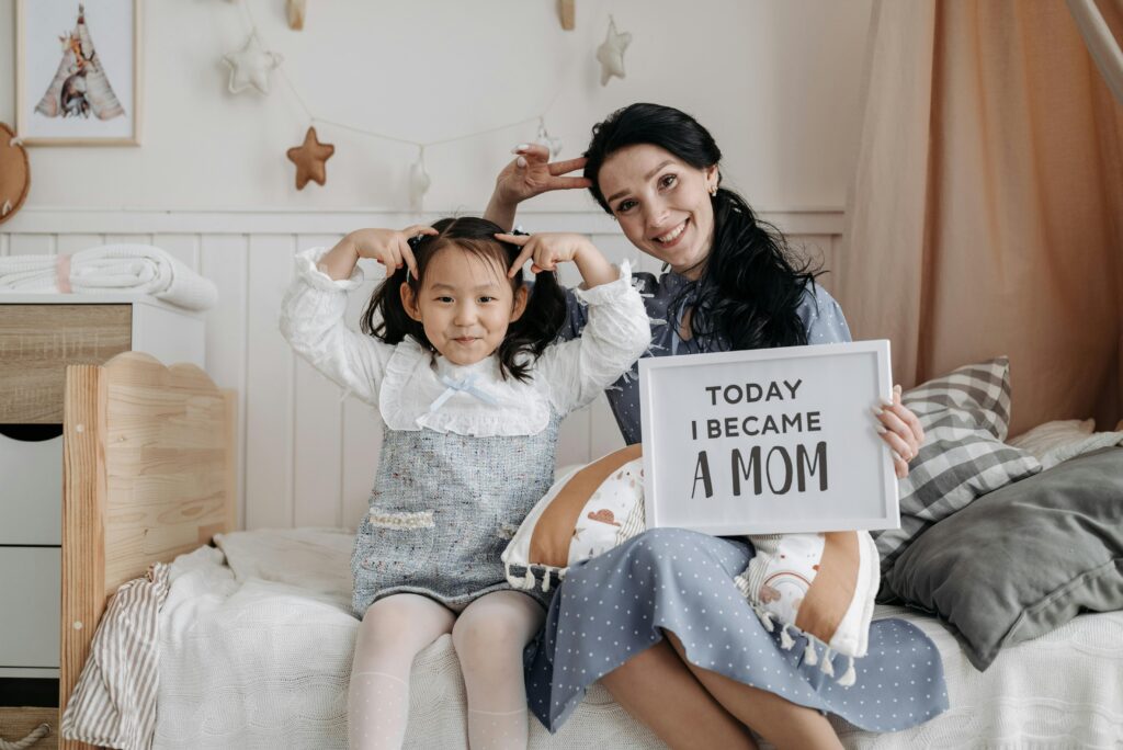 A joyful moment between a mother and her adopted daughter sitting together at home.